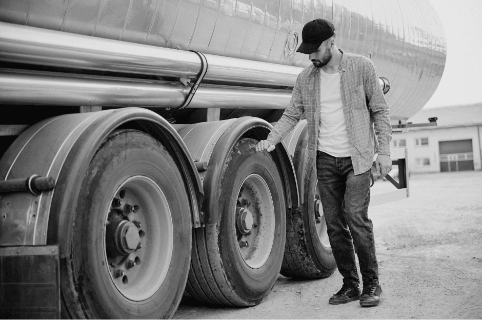 a truck driver looking at the tires on his truck